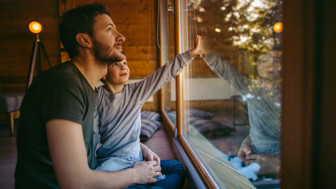 Photo of young father spending some quality time with his son during winter holidays in their log cabin