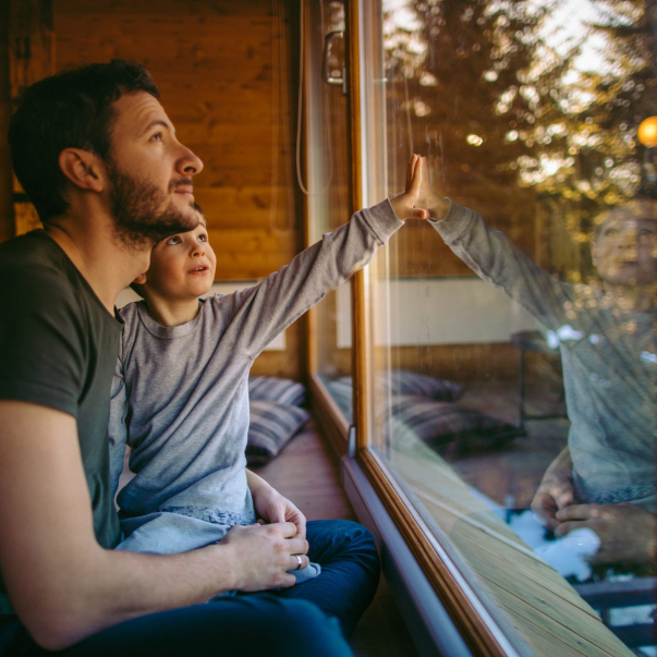 Photo of young father spending some quality time with his son during winter holidays in their log cabin