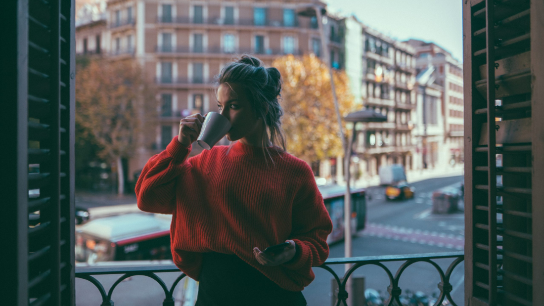 Young woman relaxing at the terrace and drinking coffee