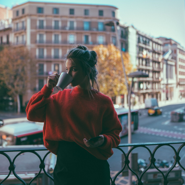 Young woman relaxing at the terrace and drinking coffee